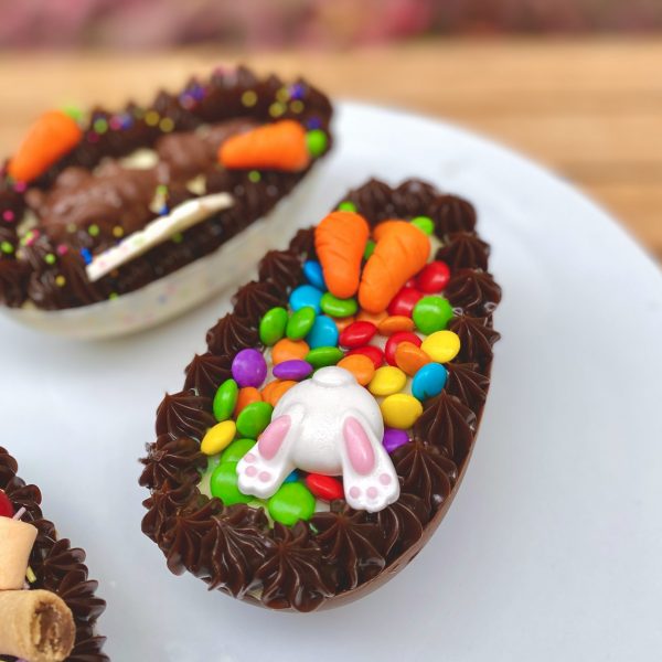 Irresistible huevo de Pascua con decoración adorable de patitas y conejito.