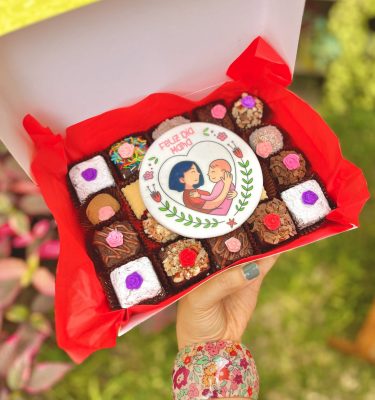 Una caja de postres surtidos decorados para el Día de la Madre.