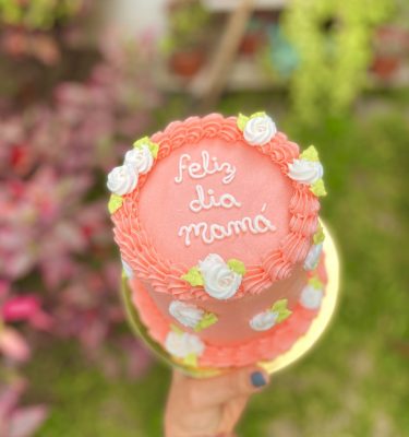 Encantadora mini torta de chocolate decorada con flores de buttercream y un topper especial para celebrar el Día de la Madre.