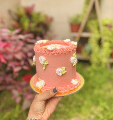 Encantadora mini torta de chocolate decorada con flores de buttercream y un topper especial para celebrar el Día de la Madre.