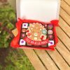 Variedad de postres en una caja decorada con temática de mamá osa para el Día de las Madres.