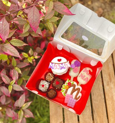 Delicioso surtido de postres decorados especialmente para el Día de la Madre en una caja sorpresa.