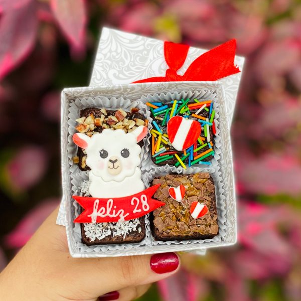 Cuatro mini postres decorados con fondant y toppings, presentados en una caja ecológica con opción de sticker personalizado.