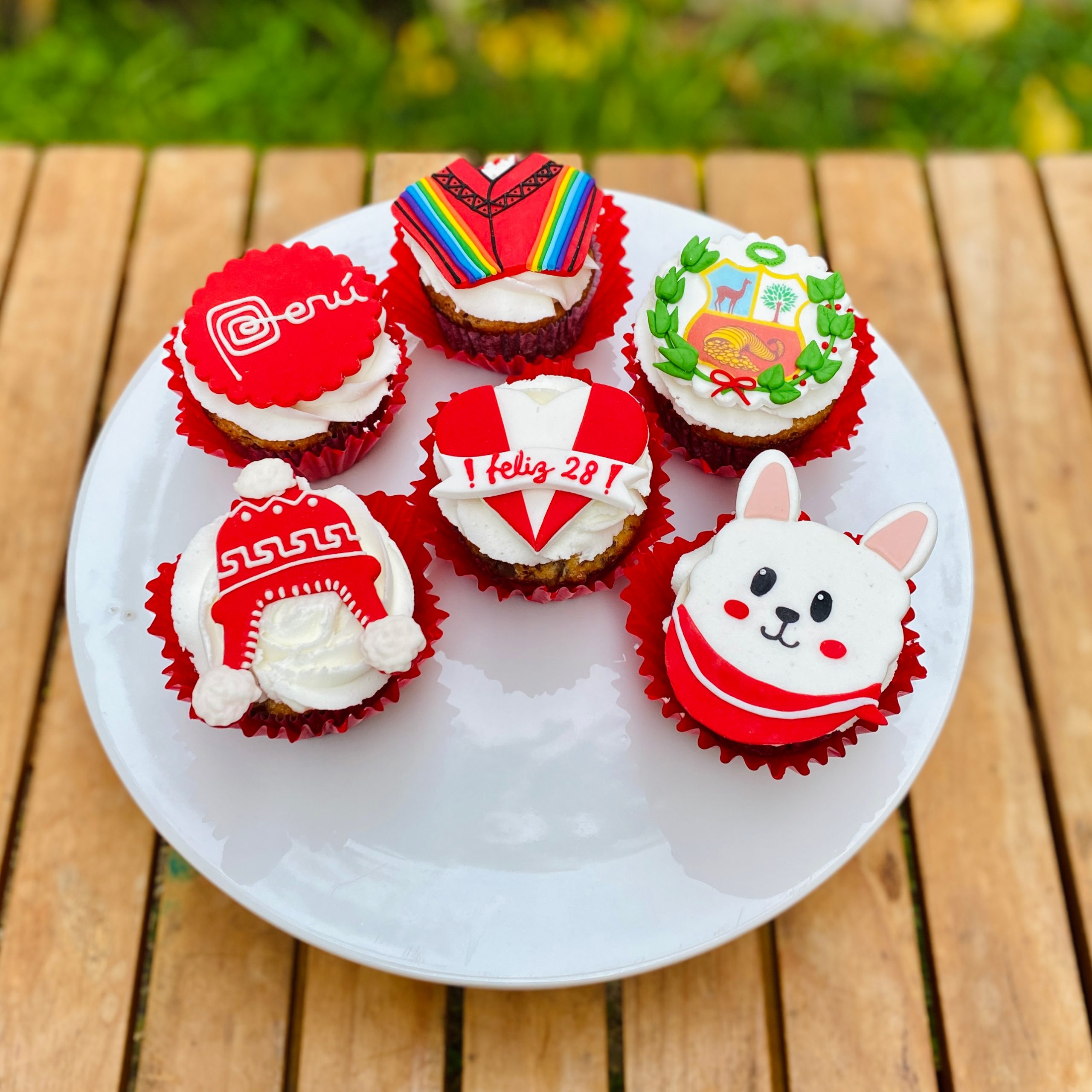 IMG_4201 Set de 6 cupcakes con frosting rojo y blanco, presentados en una caja blanca con ventana.