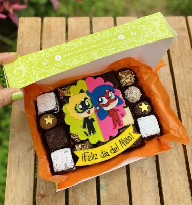 Mix Box Ladybug con 20 postrecitos surtidos decorados con arte en oblea de LadyBug, empaquetado en una caja marrón vintage con lazo de tela.