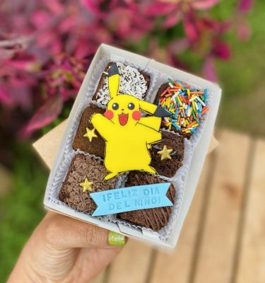Mini Six Pikachu decorado con fondant y toppings variados, empaquetado en una caja ecológica con opción de sticker personalizado.